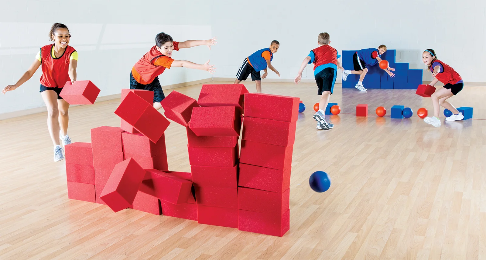 Elementary school students playing a block-em invasion game in a gym