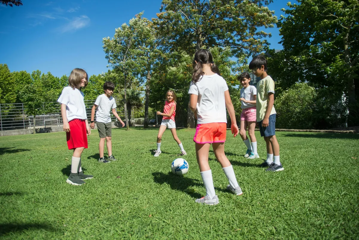 Group of kids playing football on a field outdoors